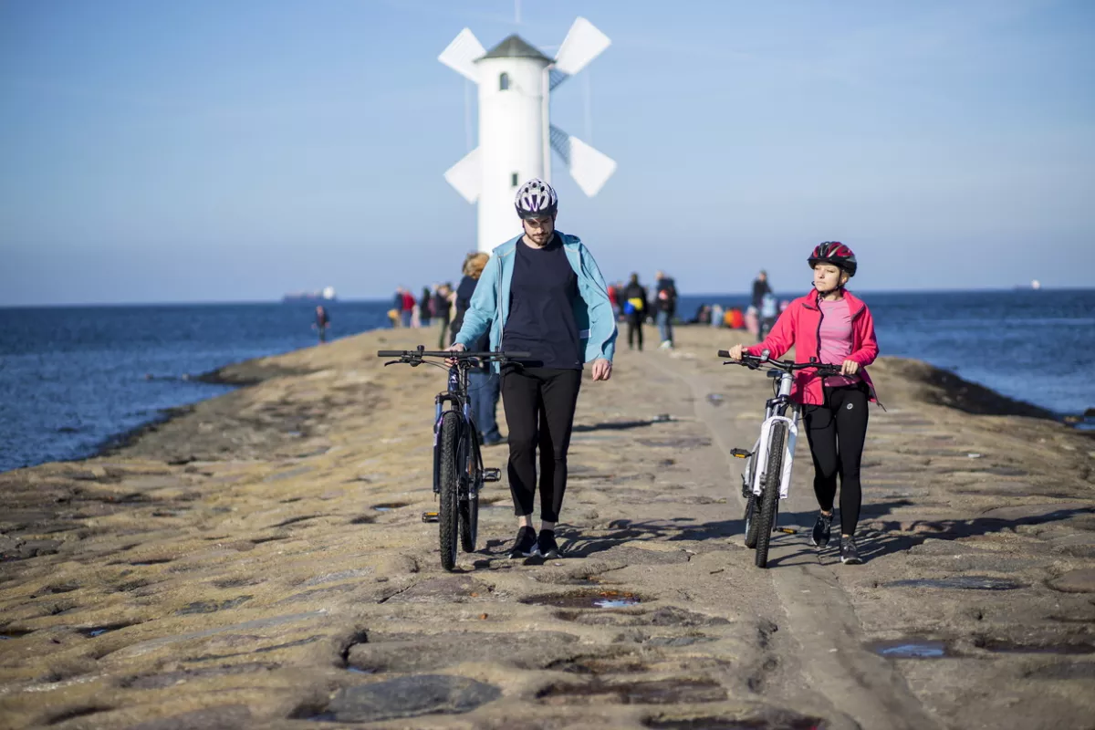 Velo Baltica – twee fietsers lopen met fiets aan de hand langs de Baltische kust